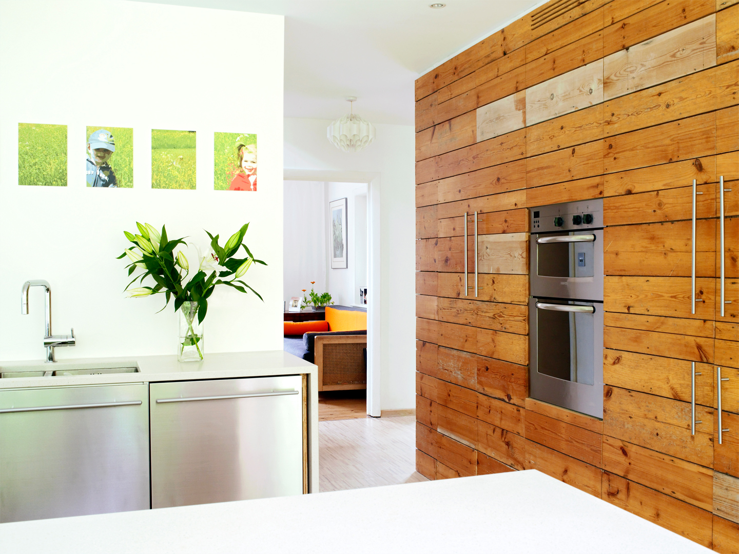 The white kitchen countertops are contrasted with wood panelled units.